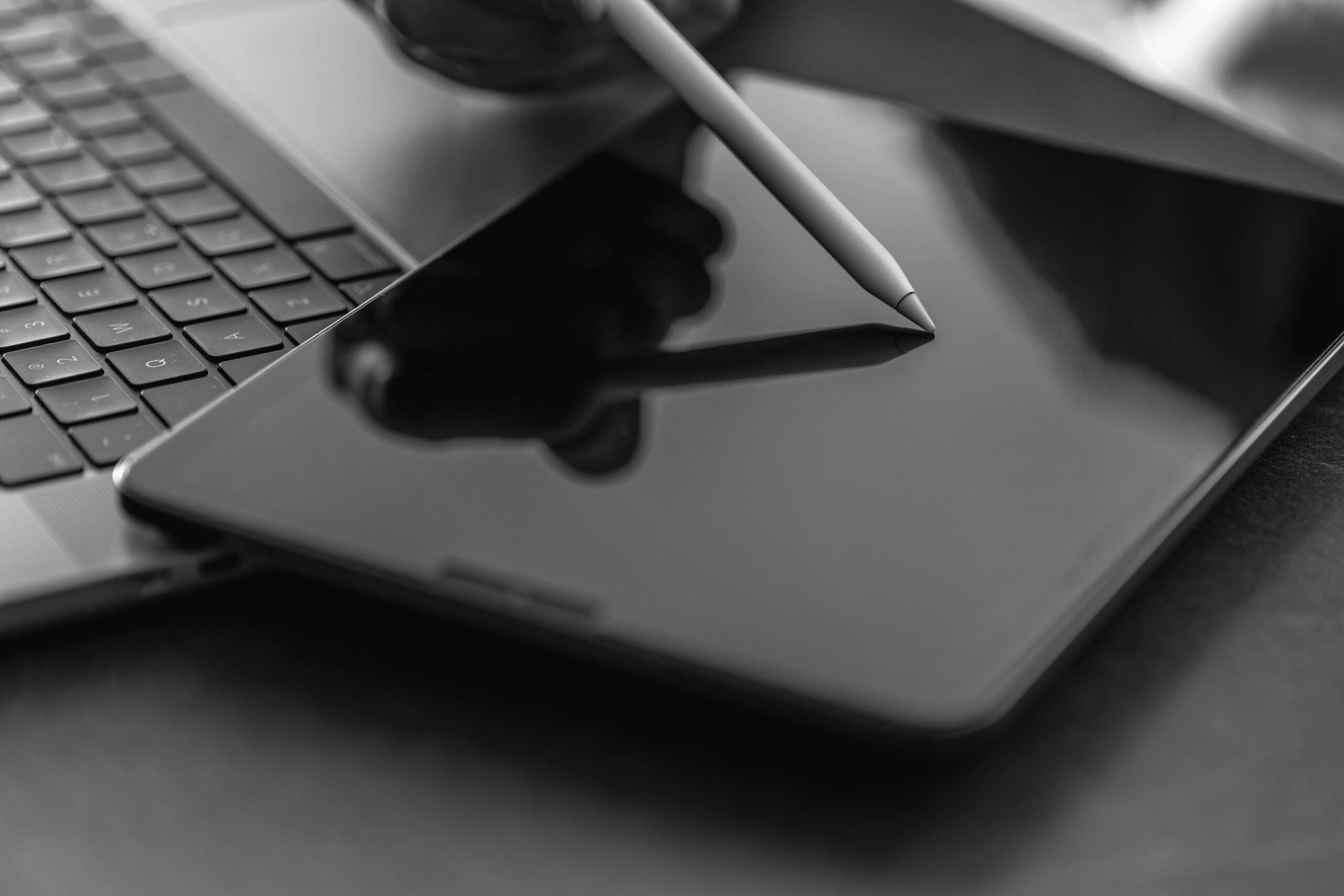 Man using digital tablet, holding stylus pen, working in office. man using MacBook